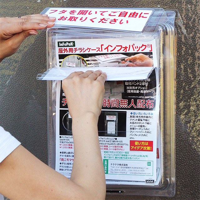フタを持ち上げてチラシを取り出す手元